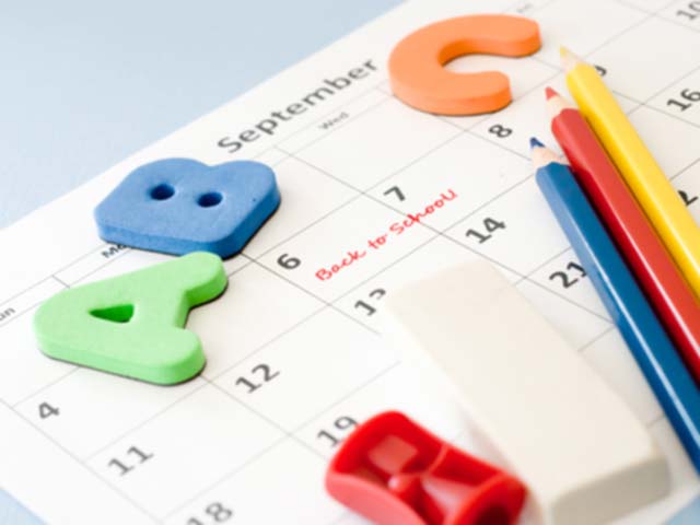 Calendar with  letter tiles, pencils, eraser, and sharpener